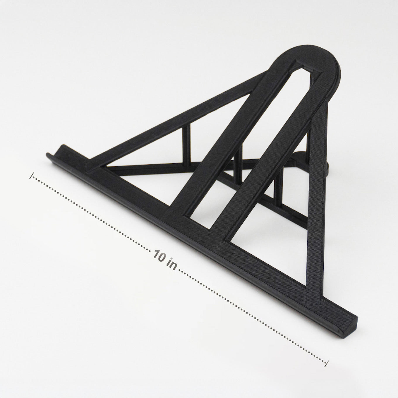 A black lego display stand with a slanted top, labeled "10 in" for scale, on a white surface.